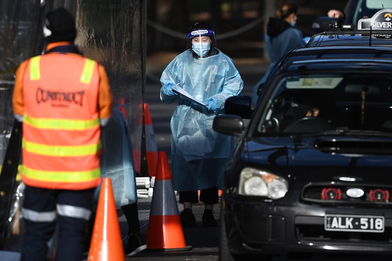 A healthcare worker carries out a Covid-19 test at a drive-through testing facility in Melbourne, Australia. EPA