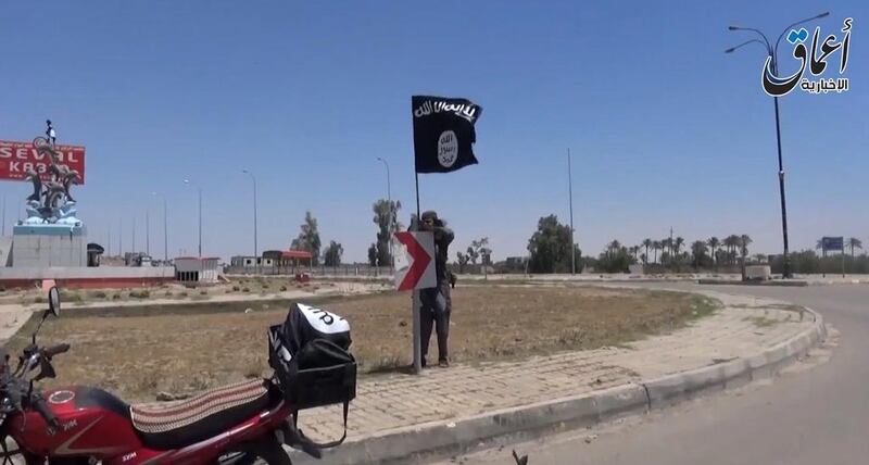 A video frame showing an ISIL fighter hanging a flag in Ramadi, the capital of Anbar province. (AAMAQ / AFP)