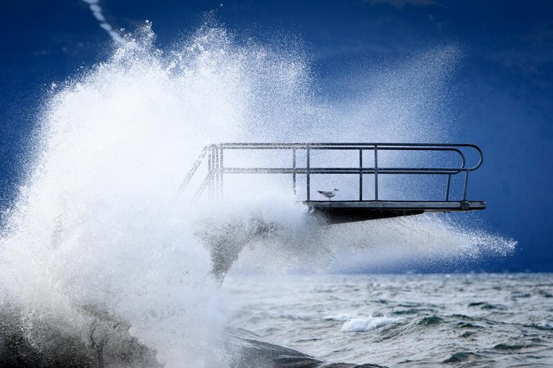 Waves hit a diving board during the Ciara storm on the shore of the Lake Geneva, in Lutry, Switzerland, Monday, Feb. 10, 2020. Severe warnings have been issued for Western and Northern Europe as storm Ciara (also known as Sabine in Germany, and Switzerland and Elsa in Norway) is bringing strong winds and heavy rains causing disruption of land and air traffic.  (Laurent Gillieron/Keystone via AP)
