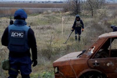 Ukrainian experts scan for unexploded ordnance and landmines by the main road to Kherson on November 16, 2022. Reuters