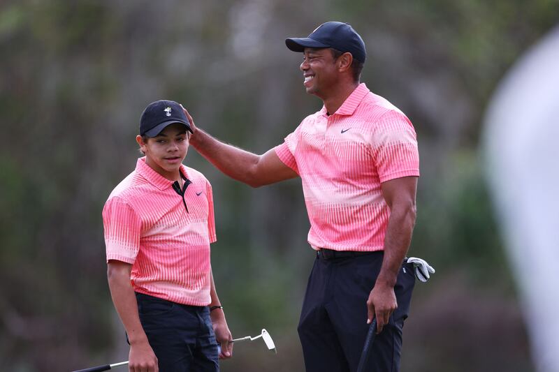 Tiger Woods and Charlie Woods celebrate on the seventh green during the first round of the PNC Championship. AFP