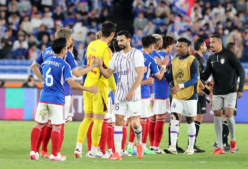 Khalid Al Hashemi, centre, and his Al Ain teammates shake hands with the Yokohama players at full time. Chris Whiteoak / The National
