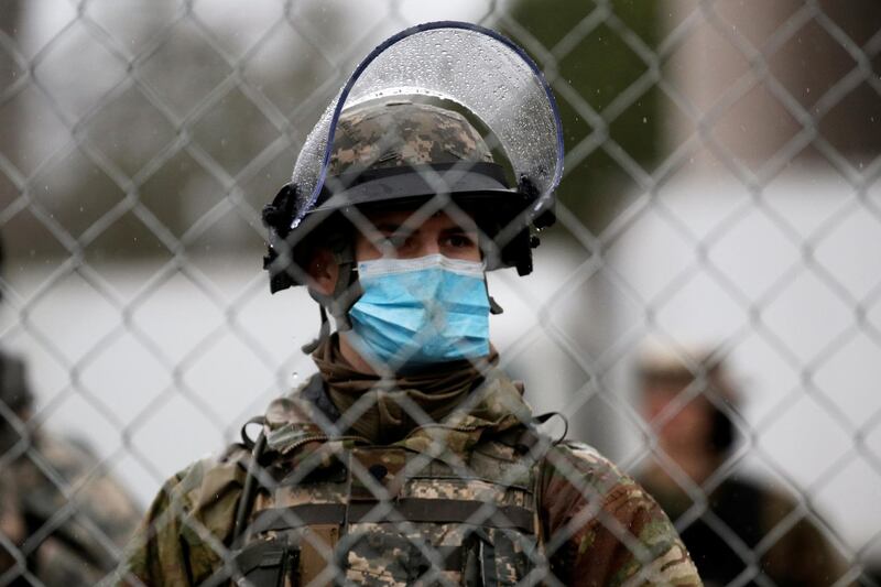 A member of the Washington State National Guard stands behind security fence outside the Washington State Capitol Building, as the 2021 Legislative session begins in Olympia, Washington, U.S January 11, 2021. REUTERS/Lindsey Wasson