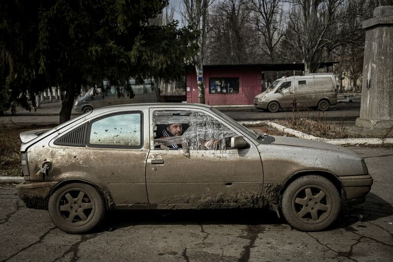 A man sits inside a damaged car in the village of Chasiv Yar. AFP