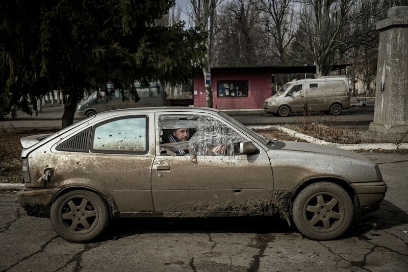 A man sits inside a damaged car in the village of Chasiv Yar. AFP