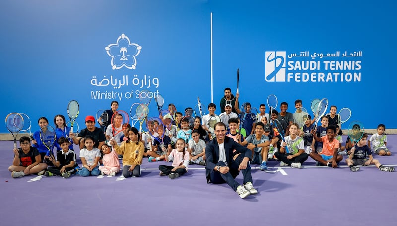 Rafael Nadal poses for a photo with children who took part in his tennis clinic held at Mahd Academy.