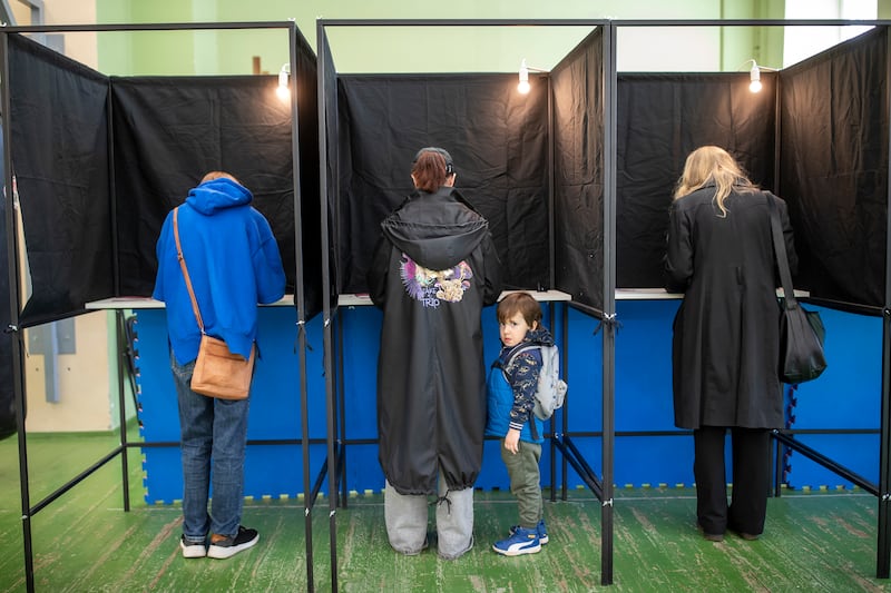 A boy looks on from a voting booth in Vilnius, Lithuania. If no candidate wins more than 50 per cent, a run-off vote will be held on May 26. AP
