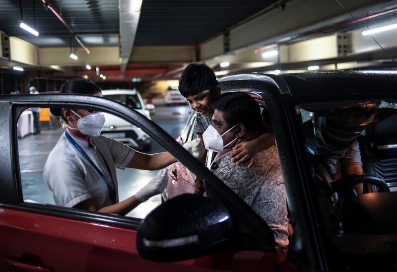 Children watch their father getting inoculated during a drive in facility for Covid-19 vaccination at the Lulu shopping mall in Kochi, Kerala. AP