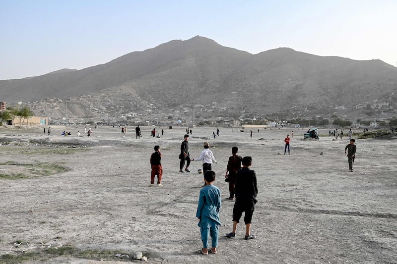 Children play football on a dried-up lake bed in Kabul.
