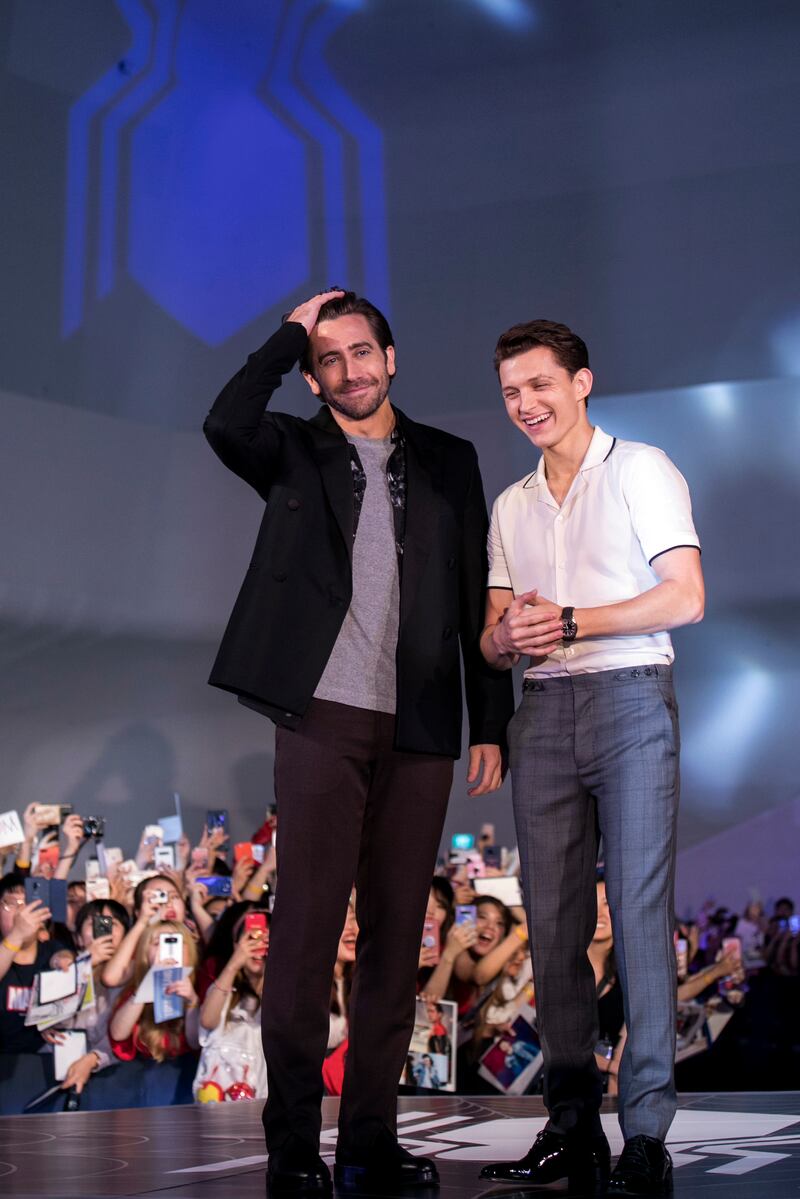 Jake Gyllenhaal and Tom Holland, in a white bowling shirt and grey trousers, attend a 'Spider-Man: Far From Home' fan event in Seoul on June 30, 2019. Getty Images