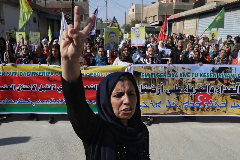 Kurdish and Arab protesters chant slogans against Turkish President Tayip Erdogan as they walk during a march to the United Nations Headquarters in the town of Qamishli, Syria. REUTERS