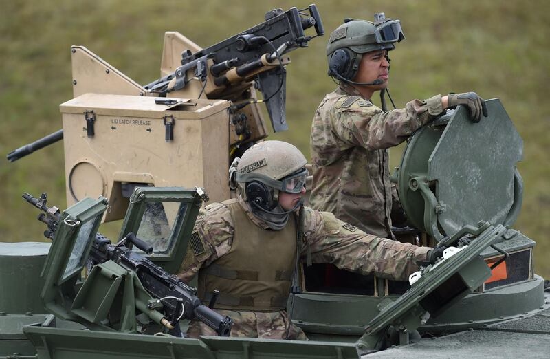 (FILES) In this file photo taken on May 12, 2017, US soldiers sit in a tank type 'M1A2 SEP'  during the exercise 'Strong Europe Tank Challenge 2017' at the exercise area in Grafenwoehr, Germany. Germany on June 7, 2020, voiced concern at reports that US President Donald Trump plans to cut the number of US troops stationed in Germany, amid fears it could weaken a key pillar of NATO defence in the region. / AFP / Christof STACHE
