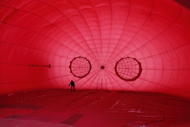 A participant prepares a hot-air balloon during Russia's 'Festival of Hearts' balloon event, in Dmitrov, about 70km north of Moscow. EPA