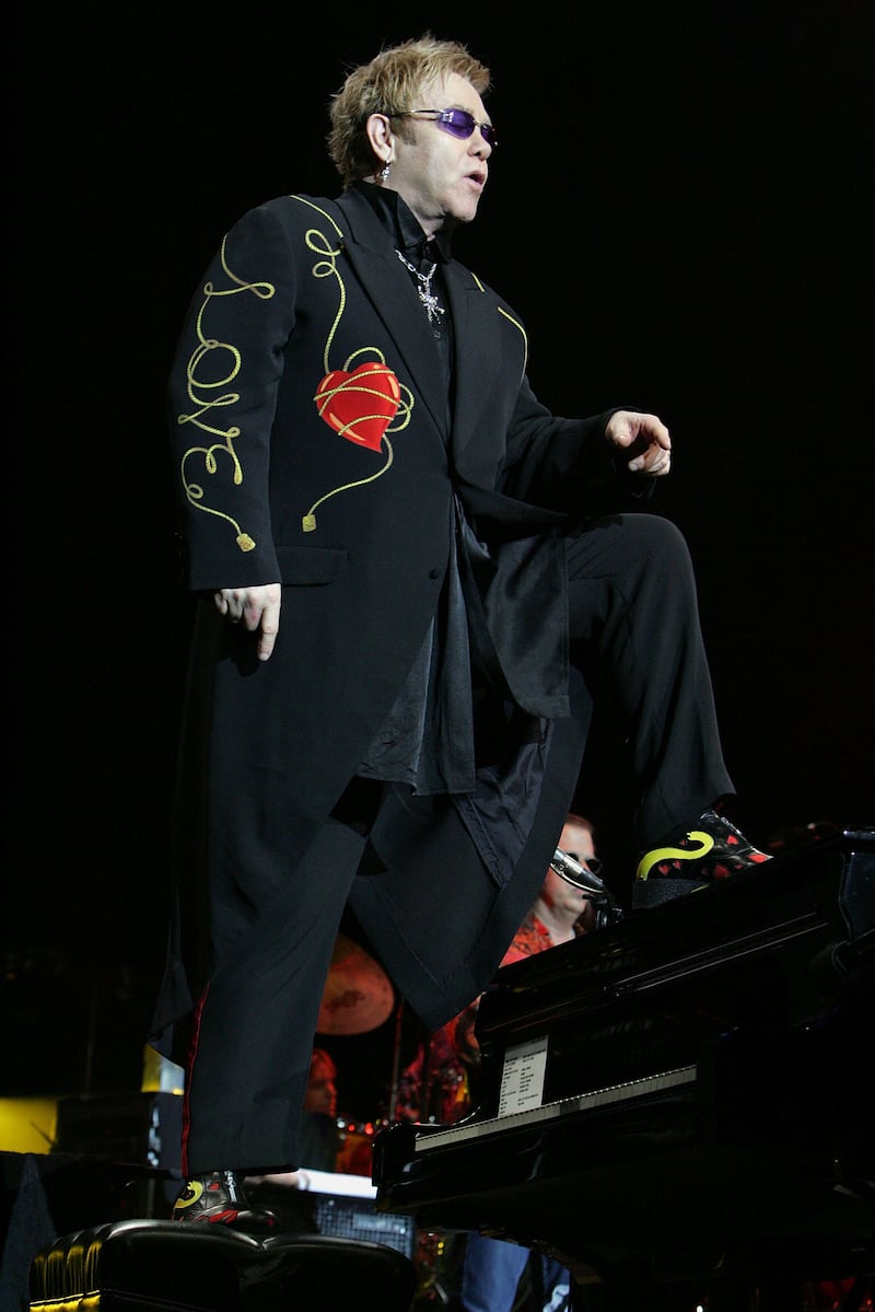 Elton John, in a black suit with a 'love' print, performs in Sydney, Australia on May 12, 2008. Getty Images