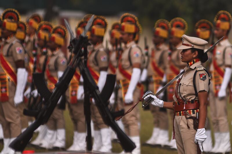 An officer stands at attention with a group of Indian Railway Protection Force personnel. EPA