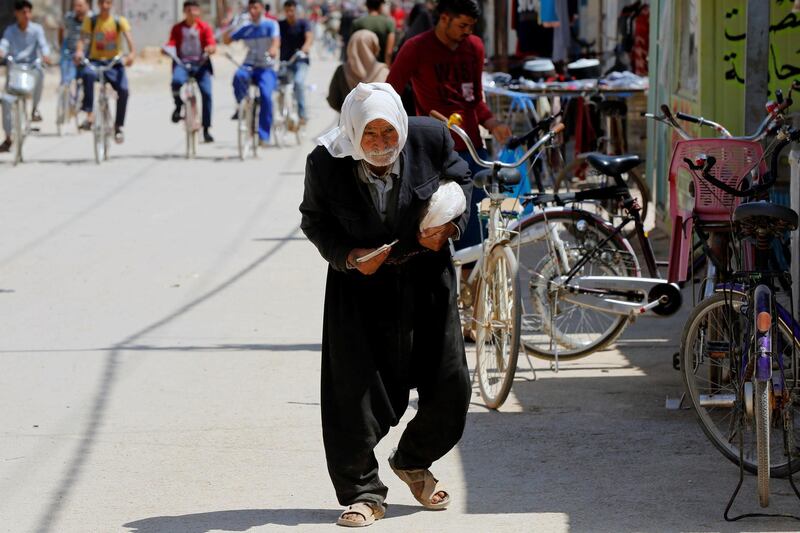 A Syrian refugee man walks on the main market street in the Al-Zaatari refugee camp in the Jordanian city of Mafraq, near the border with Syria, July 30, 2018. Picture taken July 30, 2018. REUTERS/Muhammad Hamed