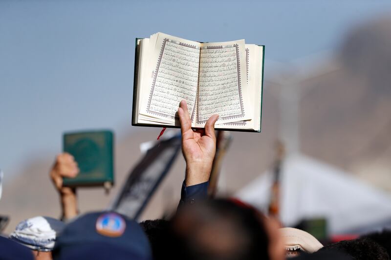 A Yemeni protester holds up a copy of the Quran. EPA