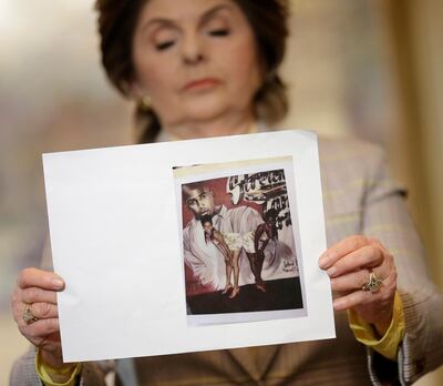 Attorney Gloria Allred holds up a picture of Latresa Scaff, left, and Rochelle Washington, posing in front of a picture of R. Kelly, on the night they claim they became victims of his sexual advances during a news conference in New York, Thursday, Feb. 21, 2019. Scaff and Washington are accusing musician R. Kelly of sexual misconduct on the night they attended a concert of his while they were teenagers.(AP Photo/Seth Wenig)