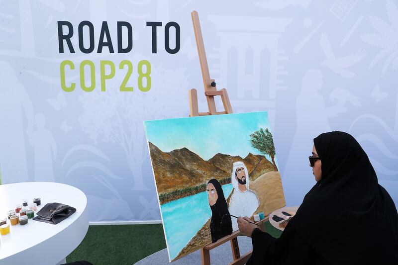 An artist at work on an Emirati scene at the Road to Cop28 launch