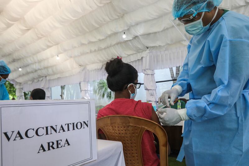 An army medical worker in Colombo, Sri Lanka, vaccinates staff working in the education sector with the Sinopharm shot.