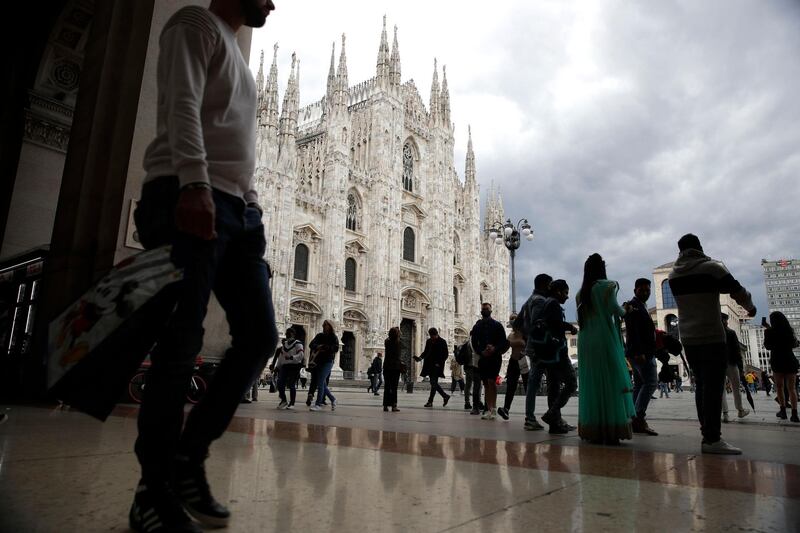 People walk in front of the Duomo gothic cathedral in Milan, Italy. AP Photo