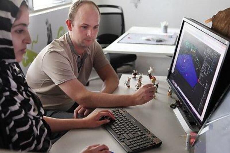 Matthew Bell, head lecturer at twofour54's Gaming Academy, helps a student. The academy was set up with French developer Ubisoft, which is responsible for titles such as Assassin's Creed. Delores Johnson / The National