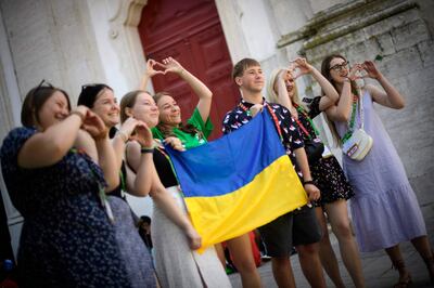 Ukrainian pilgrims pose with their national flag after attending Mass at the Church of Our Lady of Grace in Lisbon. AFP