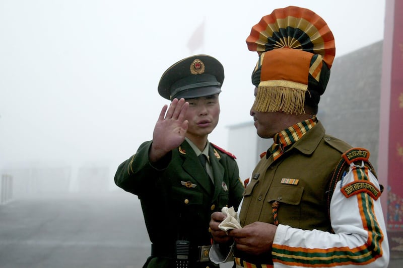 (FILES) In this file photo taken on July 10, 2008 a Chinese soldier gestures as he stands near an Indian soldier on the Chinese side of the ancient Nathu La border crossing between India and China. Indian and Chinese troops have became embroiled in a new brawl on their contested border which left injuries on both sides, barely six months after a deadly clash in the Himalayas, military sources and media reports said.
 / AFP / Diptendu DUTTA
