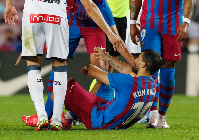 Barcelona's Sergio Aguero goes down after signalling to the bench. Reuters
