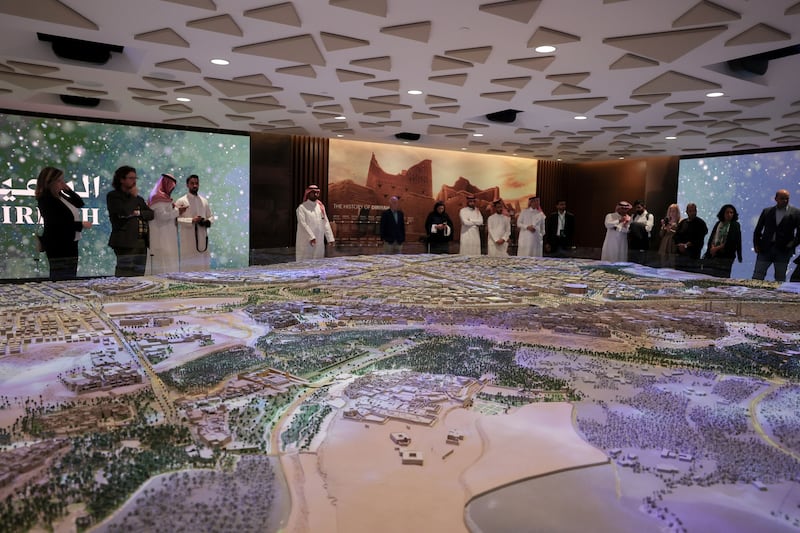 Visitors look at a model of the project