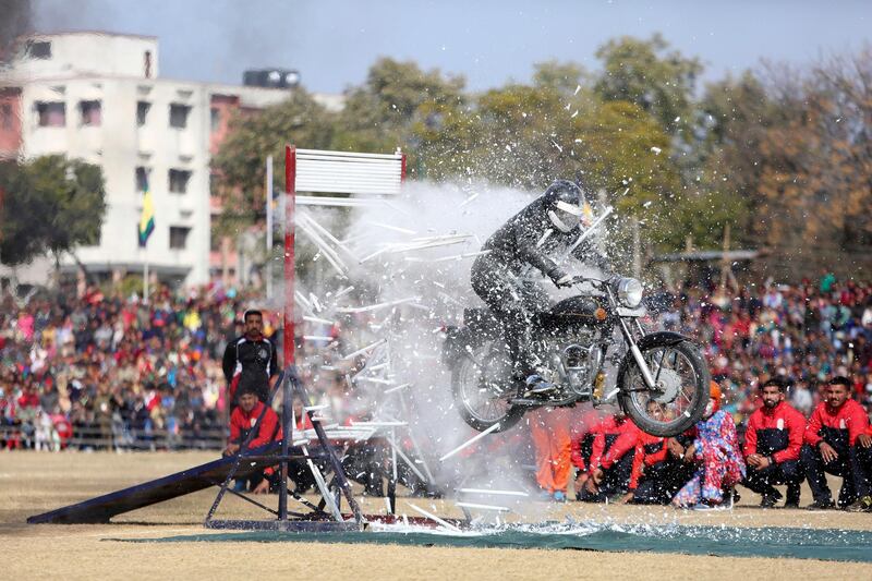 A Jammu and Kashmir state policeman performs a motorcycle stunt during Republic Day celebrations in Jammu, India.  AP