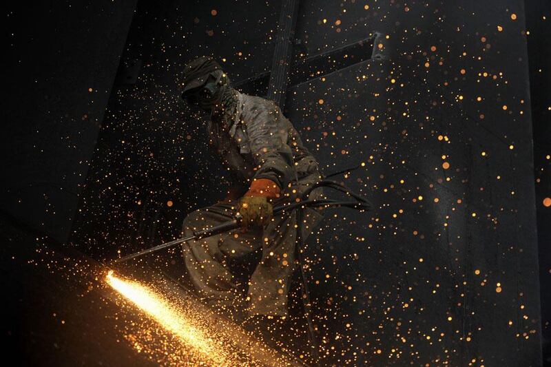 Back to work: a blow torch is used to cut through metal inside the hull of a vessel beached at one of Geddani's 127 ship-breaking plots.