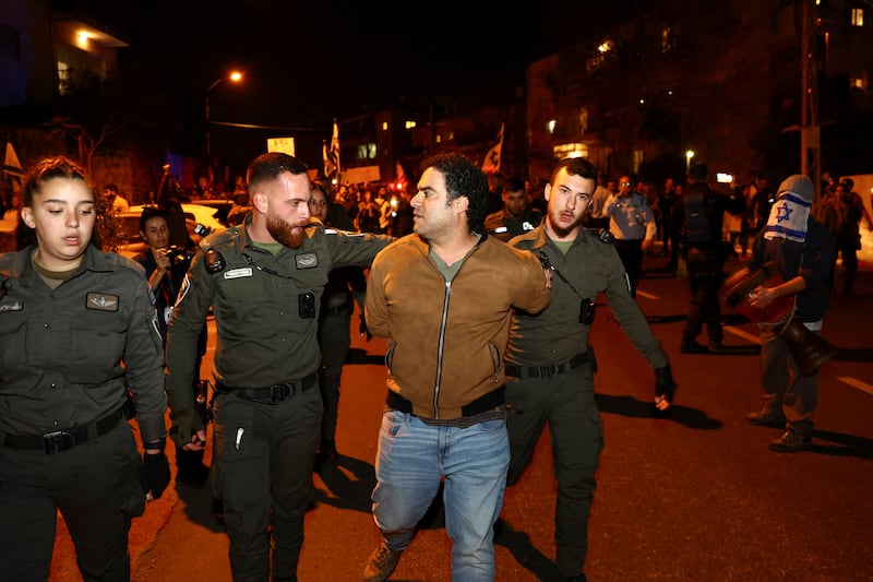 A protester being taken away by police officers in Jerusalem. Reuters