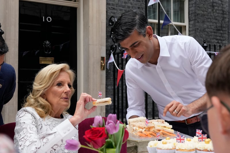 Britain's Prime Minister Rishi Sunak offers a plate of sandwiches to US first lady Jill Biden during a coronation Big Lunch in Downing Street. PA
