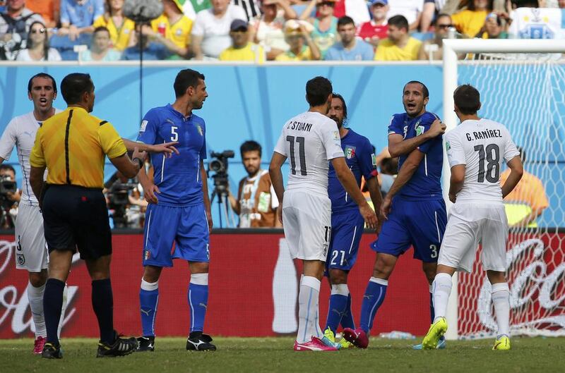 Italy's Giorgio Chiellini, second right, complains to referee Marco Rodriguez of Mexico, second left, during their 2014 World Cup Group D match on Saturday after Luis Suarez, unseen, appeared to bite him on the shoulder. Yves Herman / Reuters 