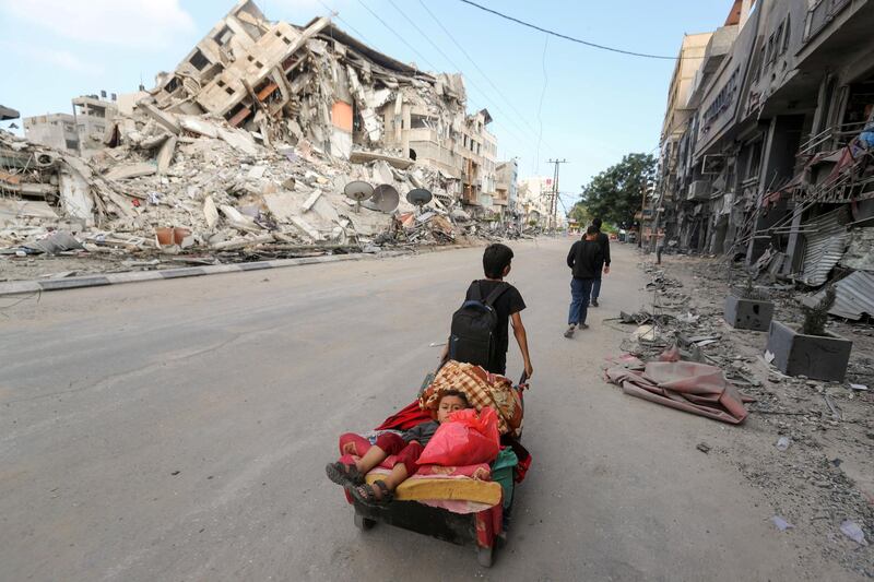 A Palestinian boy pulls a cart carrying his brother and their belongings as they flee their home during Israeli air and artillery strikes on Gaza city. Reuters