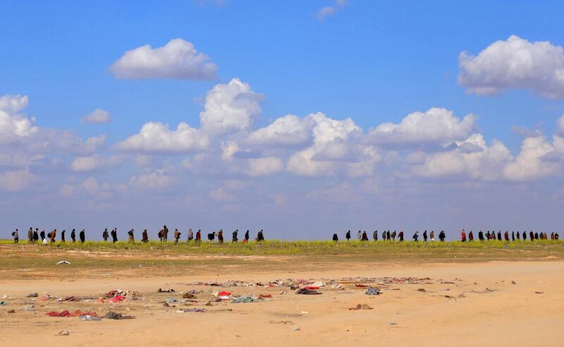 Civilians walk together near Baghouz, Der Ezzor, Syria. Reuters