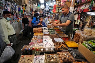 An Iraqi man sells food at the Shorja market in central Baghdad on April 12, 2021 ahead of the Muslim holy month of Ramadan after the easing of the curfew imposed by authorities amid the coronavirus COVID-19 pandemic. / AFP / AHMAD AL-RUBAYE