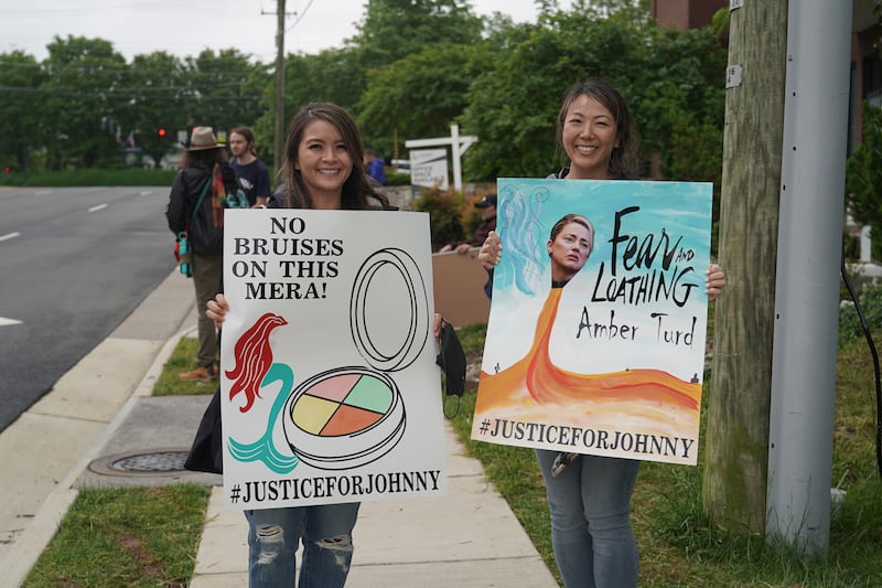 Two fans of Depp hold signs showing their support outside the courthouse. Willy Lowry / The National