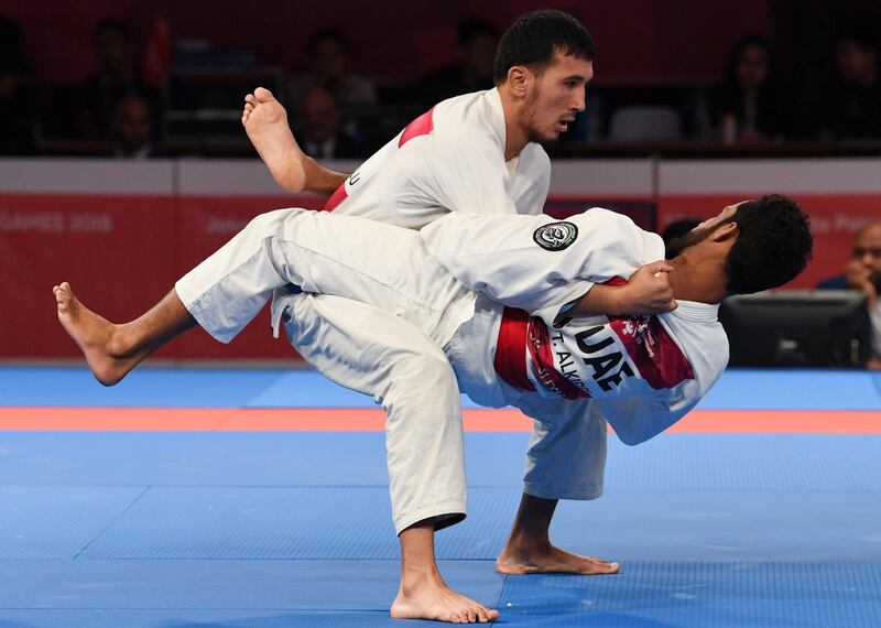 Torokan Bagynbai Uulu (L) of Kyrgyzstan competes against Talib Alkirbio of United Arab Emirates in the jujitsu newaza men's under 69kg finals during the 2018 Asian Games in Jakarta. AFP