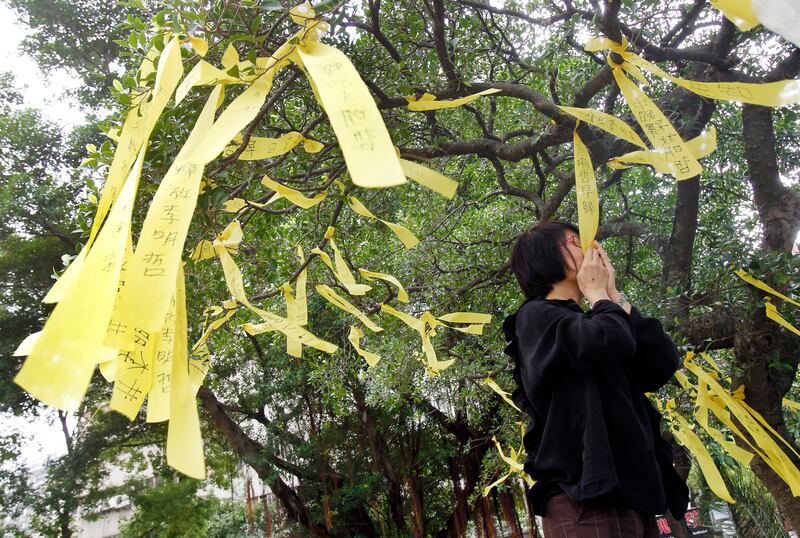 A Taiwanese supporter kisses a yellow ribbon in support of activist Lee Ming-che who is detained in China. Chiang Ying-ying / Reuters