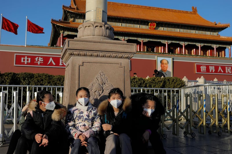 Chinese girls wear masks near the Tiananmen Gate Tower in Beijing, China.  EPA