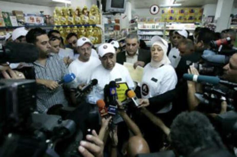 Salam Fayyad, the Palestinian prime minister, centre, talks to journalists during a visit to a supermarket in Ramallah yesterday.