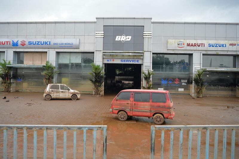 Vehicles lie abandoned at a car showroom and service station after flood waters receded at Chalakudi Taulk in Thrissur District, Kerala. AFP