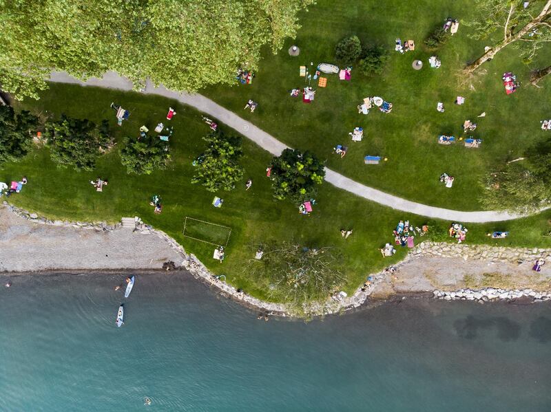 An aerial image taken with a drone shows people enjoying the evening on the shore of lake Walensee in Walenstadt, Switzerland. The country was hit by a heatwave with temperatures up to 39 degrees Celsius.  EPA