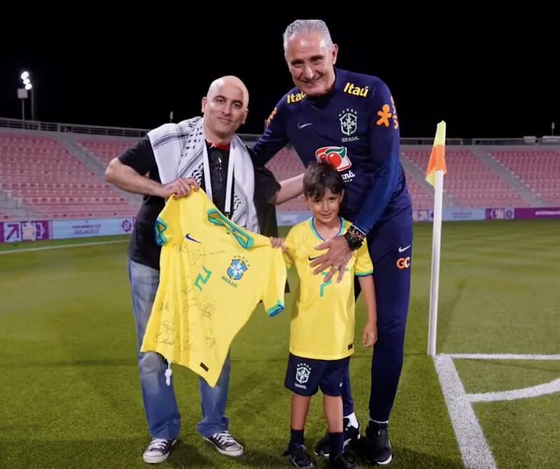 Brazil's coach Adenor Leonardo Bacchi with the Palestinian who helped carry his sleeping grandson from Doha's Lusail stadium to the metro station.
