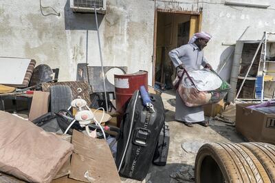 FUJEIRAH, UNITED ARAB EMIRATES. 28 DECEMBER 2017. Mubarak Sultan (gray khandoora) packs up and sorts out damaged belongings and tries to rescue some of their items at his flooded family home in the Al Ghurfa area of Fujeirah city. (Photo: Antonie Robertson/The National) Journalist: Ruba Haza. Section: National.