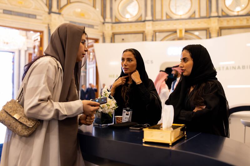 Female employees assist a guest at the conference.  Bloomberg