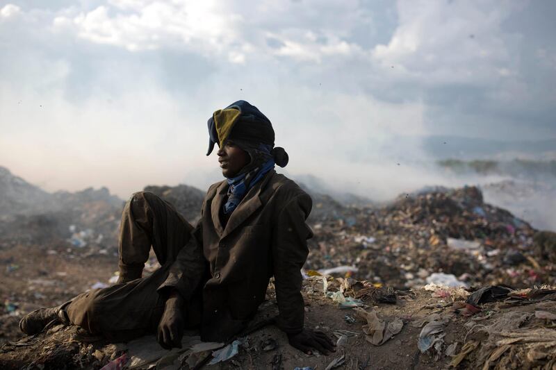 Guerdy Joseph, a 24-year-old trash scavenger, rests in his protective clothing, including a Christmas costume hat that he found in the trash, at the end of his work day at the Truitier landfill. AP Photo