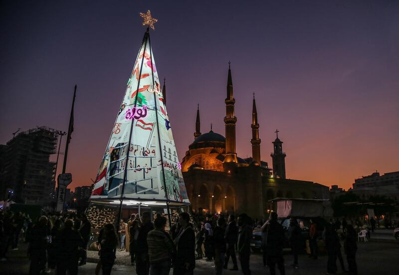 Anti-government demonstrators gather at an illuminated Christmas tree made from protest banners at Martyrs Square in Beirut. EPA